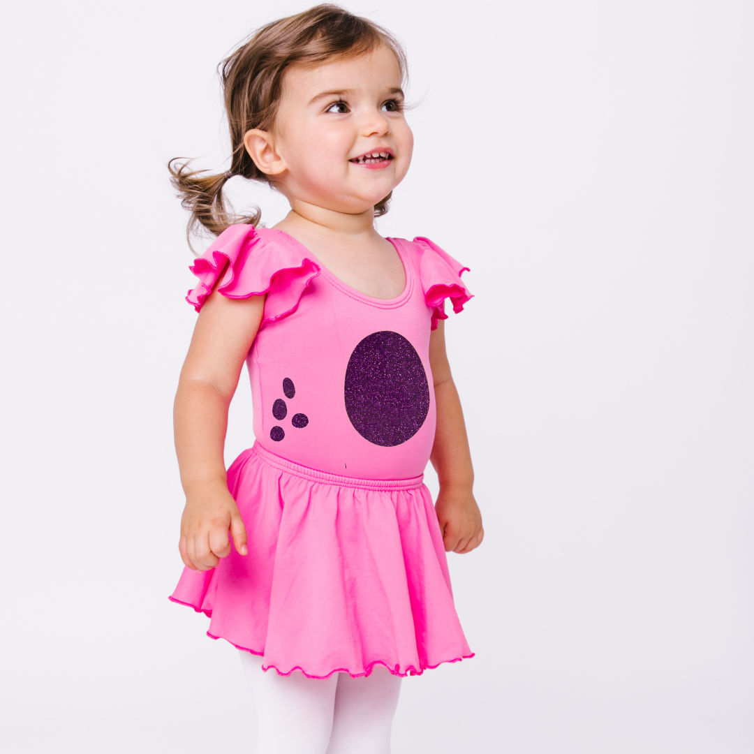 Little girl model with Bright Pink ruffle sleeve leotard with purple glitter dinosaur design.