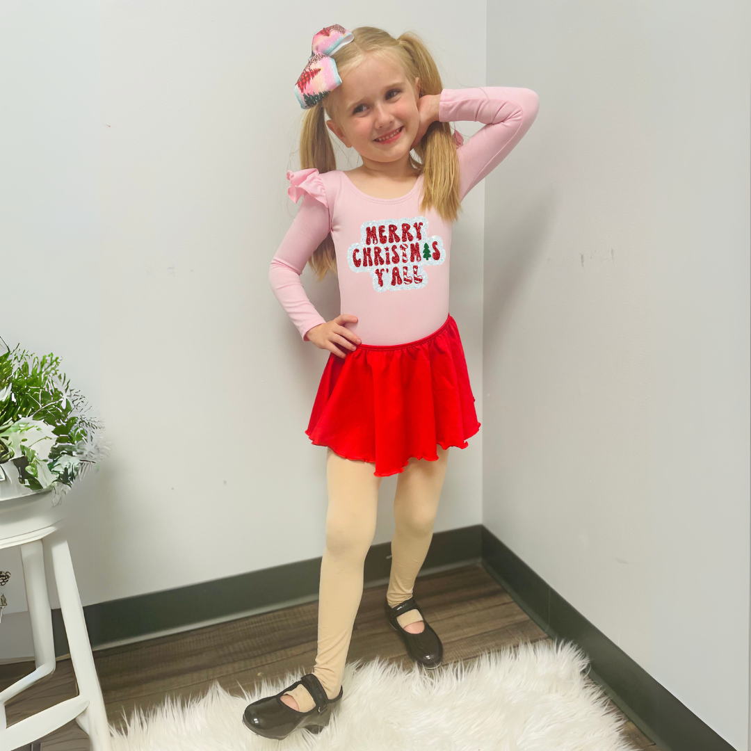 Girl wearing Light Pink Long Ruffle Sleeve Leotard with "Merry Christmas Y'all" in white, red and green glitter vinyl. 